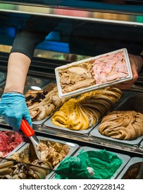 Woman Making Ice Cream Sundae For Customer