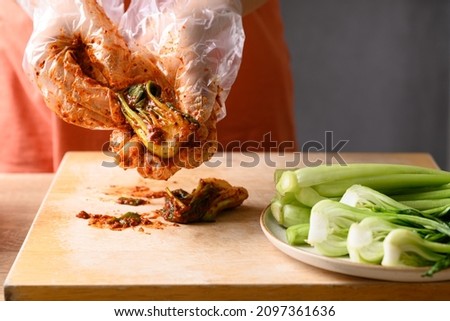 Woman making kimchi bok choy and mustard green on wooden board, Homemade Korean fermented side dish food