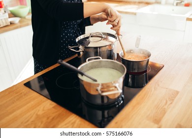 Woman Making Lunch In Kitchen And Stirring Soup