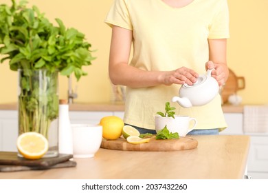 Woman Making Mint Tea In Kitchen