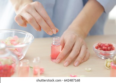 Woman Making Natural Perfume With Rose Petals, Closeup