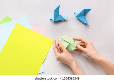 Woman Making Origami Figures At Table