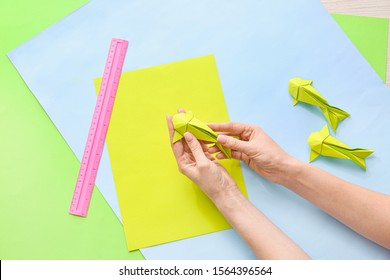 Woman Making Origami Fish At Table