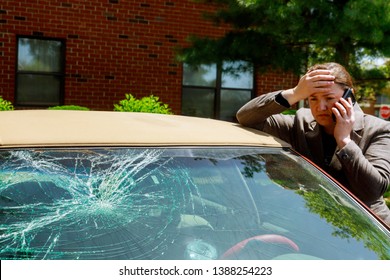 Woman making a phone call next to damaged car after a car accident