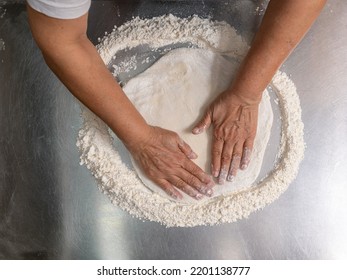 Woman Making Pizza Dough On Stainless Steel Counter