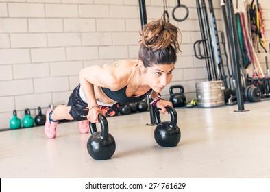 woman making push ups on the kettle bells in a gym. concept about fitness, sport and people - Powered by Shutterstock