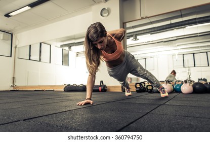 Woman making push ups on one hand. Concept about sport, fitness and wellbeing - Powered by Shutterstock