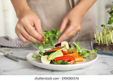 Woman Making Salad With Fresh Organic Microgreen At White Marble Table, Closeup