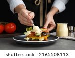 Woman making sandwich with mayonnaise at grey table, closeup