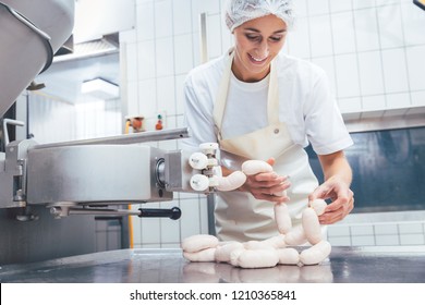 Woman making sausages from meat in butchery  - Powered by Shutterstock