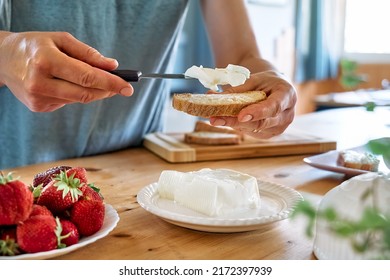 Woman Making Summer Strawberry Sandwich. Female Hands Spread Stracchino Cheese On Bread For Toast. Healthy Eating, Fruit Dieting Brunch.