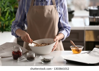 Woman Making Tasty Granola Bars In Kitchen