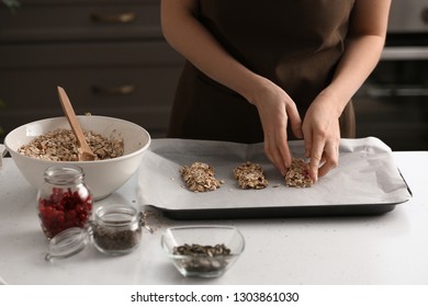 Woman Making Tasty Granola Bars In Kitchen