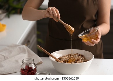 Woman Making Tasty Granola Bars In Kitchen