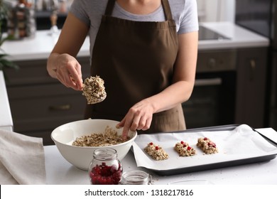 Woman Making Tasty Granola Bars In Kitchen