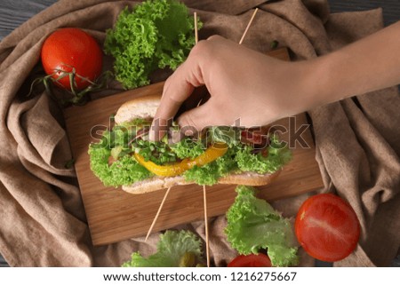 Woman making tasty hot dog, closeup