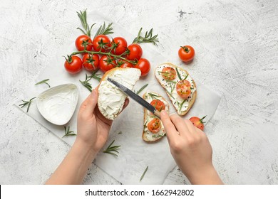 Woman making tasty sandwich with cream cheese on white background - Powered by Shutterstock