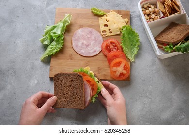 Woman Making Tasty Sandwich On Table