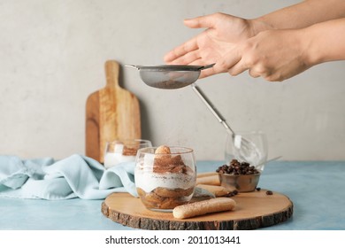 Woman making tasty tiramisu at home