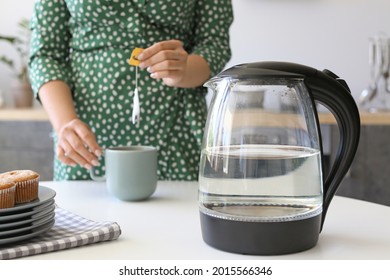 Woman Making Tea In Kitchen