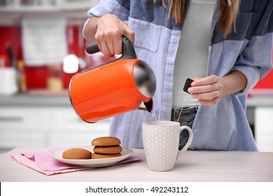 Woman Making Tea In Kitchen