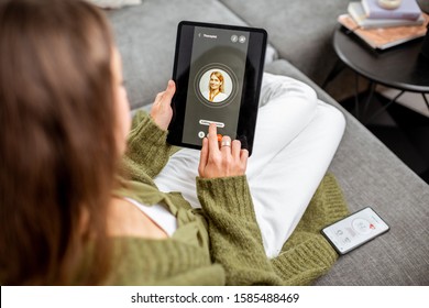 Woman making video call to a doctor using digital tablet, feeling bad at home. Concept of telemedicine and patient counseling online - Shutterstock ID 1585488469