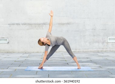 Woman Making Yoga Triangle Pose On Mat