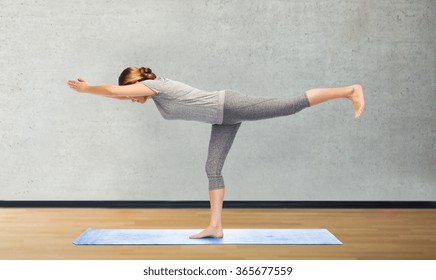 Woman Making Yoga Warrior Pose On Mat