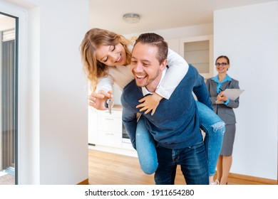 Woman and man being extremely happy about their new home having the keys in their hands