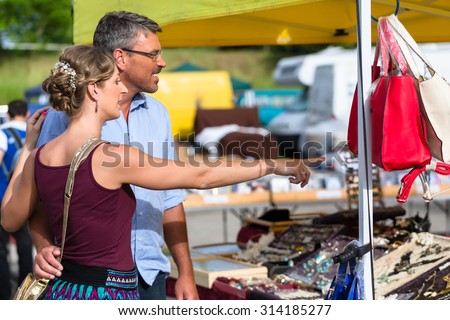 Woman and man buying stuff on flea market