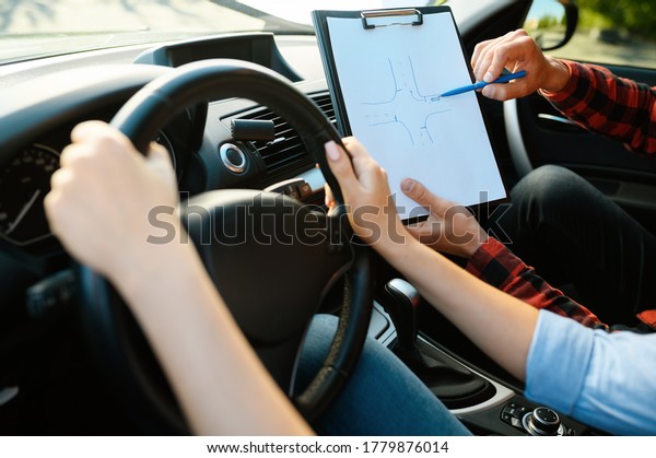 Woman and man with\
checklist, driving school