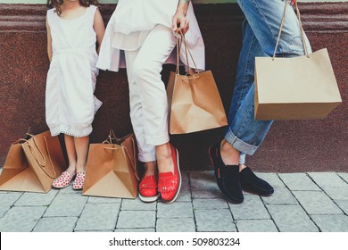 Woman, Man And Child With Shopping Bags Near The Shopping Center. Stylish Family On Sale. Concept Of Total Purchases, Style And Fashion. Family On The Shopping