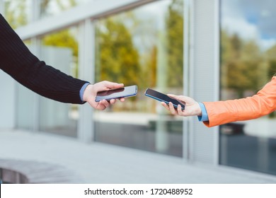 Woman and man with contact tracing app on their phones, only arms - Shutterstock ID 1720488952
