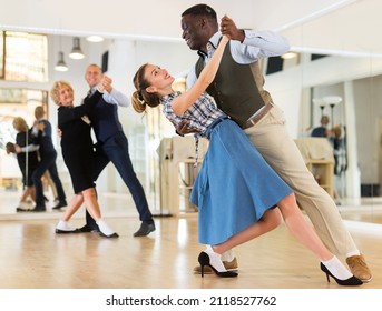 Woman and man dancing waltz in studio - Powered by Shutterstock