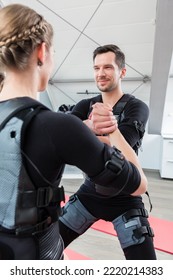 Woman And Man In Ems Gym In Partner Exercise