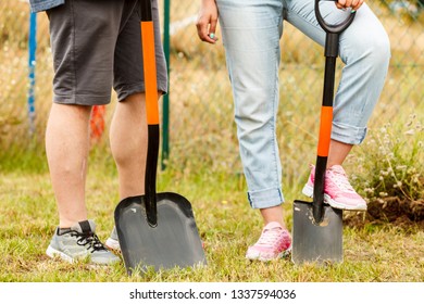 Woman And Man Gardener Digging Hole In Ground Soil With Shovel. Yard Work Around The House