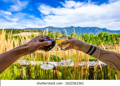 Woman And Man Hands Holding And Toasting White And Red Wine Glasses Selective Focus, Against Pampas Grass On Winery Vineyard Restaurant Terrace Patio