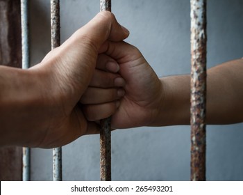 woman and man hands of jail holding prison bars - Powered by Shutterstock