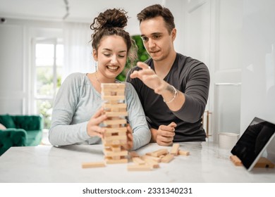 woman and man happy caucasian couple husband and wife or friends playing jenga table game at home having fun happy smile leisure time spending time together family time copy space real people - Powered by Shutterstock