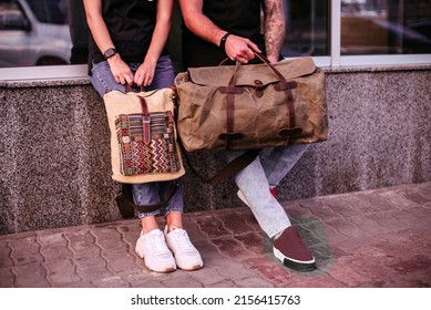 Woman and man holding canvas bags. Backpack and duffel canvas bag