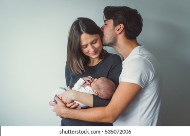 Woman and man holding a newborn.  A man kisses a woman. - Shutterstock ID 535072006