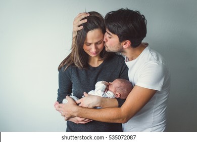 Woman and man holding a newborn.  A man kisses a woman. - Shutterstock ID 535072087