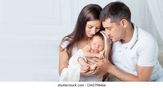 Woman and man holding a newborn. Mom, dad and baby.  Portrait of  smiling family with newborn on the hands. Happy family concept. Copy space - Shutterstock ID 1342798466