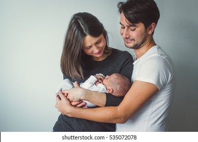 Woman and man holding a newborn. Mom, dad and baby. Close-up. - Shutterstock ID 535072078