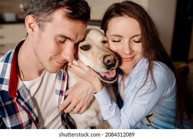 Woman and man hugging their dog labrador retriever breed