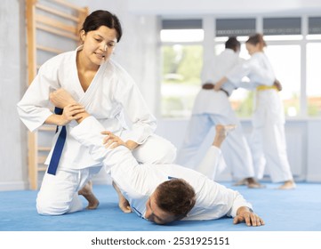 Woman and man judo fighters in sport hall. Martial arts. Sparing Portners - Powered by Shutterstock