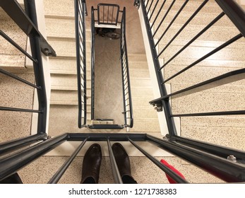 Woman Or Man Is Looking Down To Spiral Staircase At Hight Building In Hight Building As Hospital In Europe