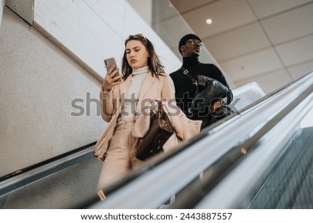 A woman and a man, modern young professionals, commuting in an urban environment, with the focus on the woman using her smart phone.