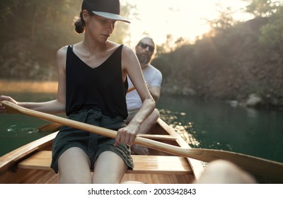 Woman And Man Paddling Canoe