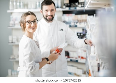 Woman And Man Pharmacists Supervising Medicaments In The Pharmacy Store